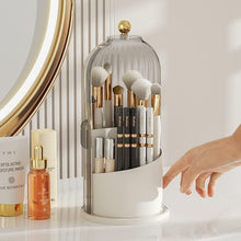 Laden Sie das Bild in den Galerie-Viewer, Elegant MessFree® makeup brush organizer with clear dome cover and gold knob, holding premium brushes on a vanity, surrounded by skincare bottles and a gold-rimmed mirror, enhancing makeup storage aesthetics