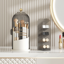 Laden Sie das Bild in den Galerie-Viewer, Elegant MessFree® makeup brush holder with clear ribbed dome and gold accent knob, displayed alongside a tiered organizer for cosmetics on a luxurious vanity setup with striped wallpaper background