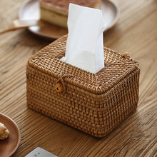 Laden Sie das Bild in den Galerie-Viewer, Handcrafted rattan tissue box cover placed on a rustic wooden table, adding a natural and eco-friendly touch to home decor. The woven design features a secure clasp, combining functionality with a charming aesthetic. Ideal for living rooms, bedrooms, or dining areas, enhancing the warmth and elegance of any setting.