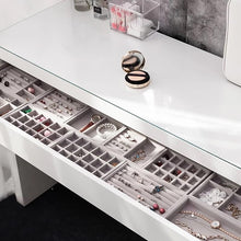 Load image into Gallery viewer, Luxurious white vanity table with a glass top showcasing elegant gray velvet jewelry trays neatly organized within the drawer. Each tray compartment holds a variety of jewelry, including rings, earrings, necklaces, bracelets, and watches, emphasizing functional elegance and efficient organization. Ideal for decluttering and displaying accessories while enhancing the aesthetics of a dressing area.