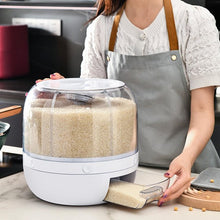 Laden Sie das Bild in den Galerie-Viewer, Person in an apron using a MessFree® rotating grain dispenser filled with rice. The dispenser features a transparent, compartmentalized design, with a pull-out tray at the base to conveniently measure and dispense the desired amount of rice.