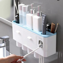 Laden Sie das Bild in den Galerie-Viewer, Multifunctional wall-mounted bathroom organizer featuring an automatic toothpaste dispenser, spacious compartments for toiletries, and a sleek storage shelf for added convenience. This compact unit keeps your daily essentials organized and within easy reach, making it ideal for maximizing space and maintaining a clutter-free sink area