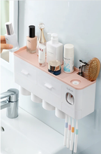 Laden Sie das Bild in den Galerie-Viewer, Wall-mounted multi-functional bathroom organizer with ample storage for cosmetics and skincare, featuring dual drawers, toothbrush holders, and a built-in toothpaste dispenser. Perfect for maintaining a tidy bathroom space, this organizer offers easy access to your daily essentials while enhancing countertop organization.
