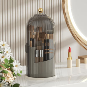 Stylish MessFree® makeup brush holder with tinted dome cover and gold knob on vanity table, ideal for organizing brushes and cosmetics, complemented by flower arrangement and lipstick accessory