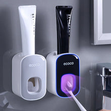 Laden Sie das Bild in den Galerie-Viewer, Grey and black toothpaste dispensers in use
