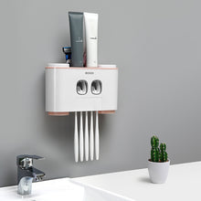 Load image into Gallery viewer, Ecoco wall-mounted toothbrush holder with dual toothpaste dispensers, designed to organize toothbrushes and toothpaste in a sleek, space-saving setup; minimalist white and soft pink accents complement modern bathroom decor, featuring hygienic compartments for multiple items and easy-access functionality.
