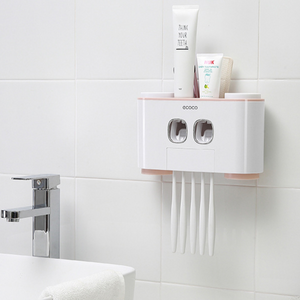 "Wall-mounted toothbrush holder with dual automatic toothpaste dispensers by Ecoco, featuring storage for multiple toothbrushes and toothpaste tubes, perfect for organizing bathroom essentials in a compact and hygienic way, minimalist white and pink design on tiled bathroom wall, ideal for family use and space-saving bathroom storage.